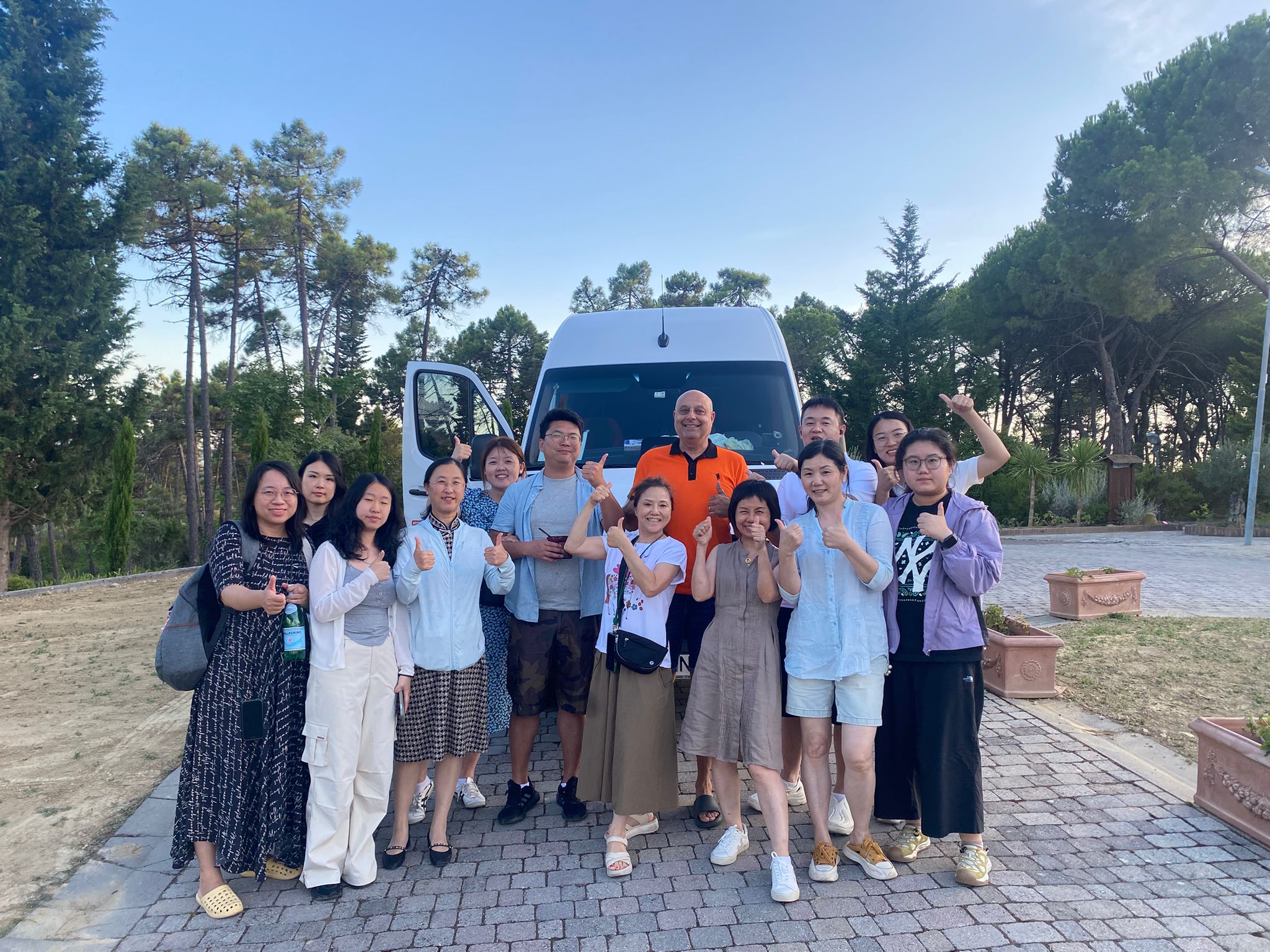 Group of tourists next to minibus at sunset